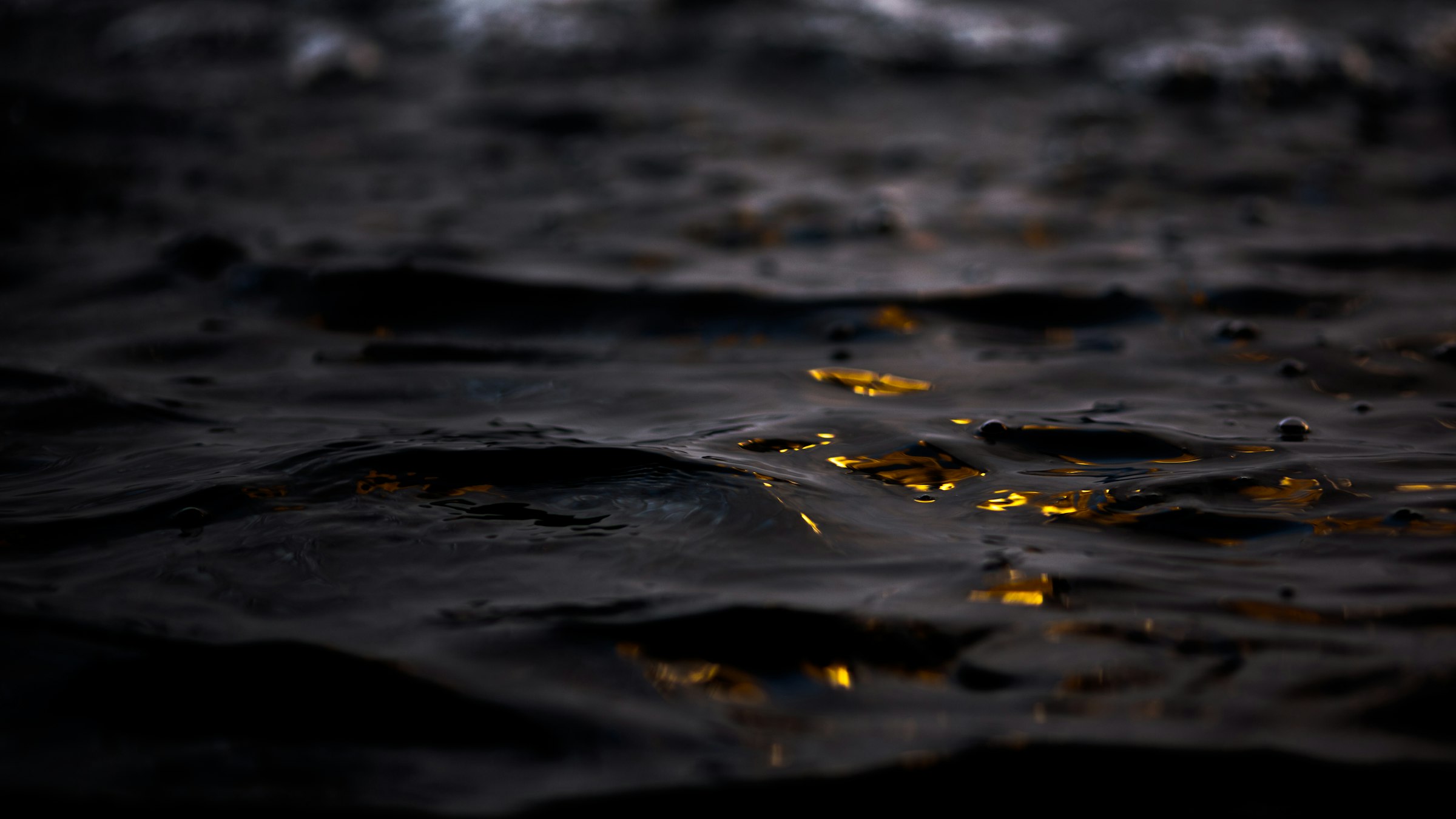 Goldene Lichtreflexe auf dunklem Wasser
